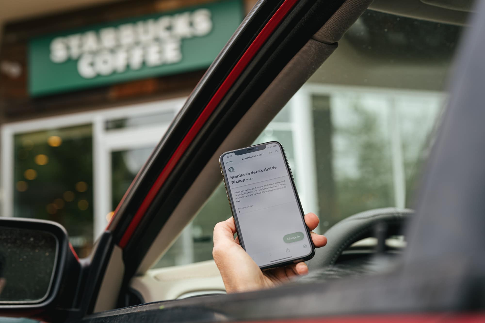 Motorista usando o app Starbucks para pegar um takeaway
